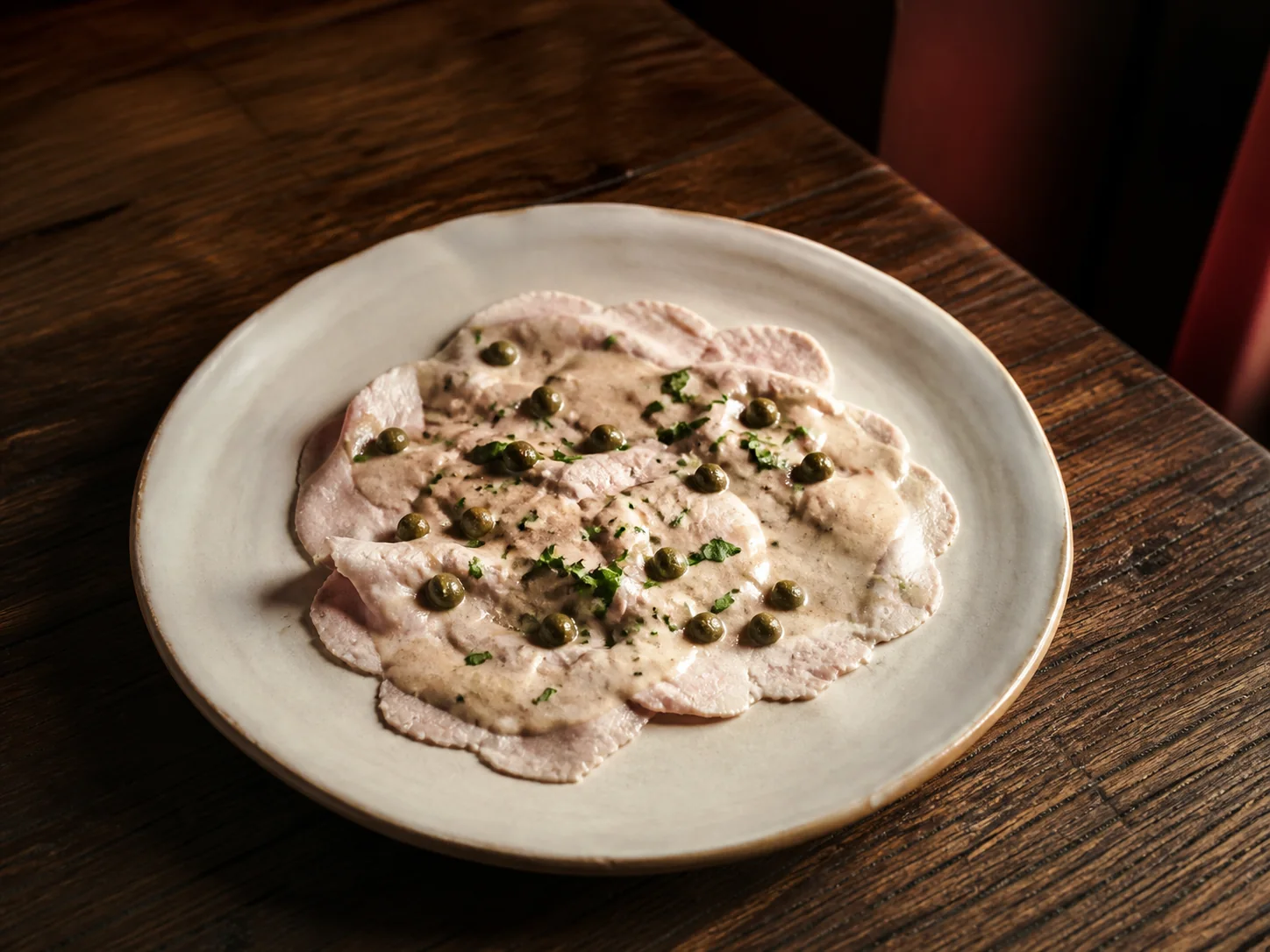 Vitello tonnato servito su un piatto di ceramica